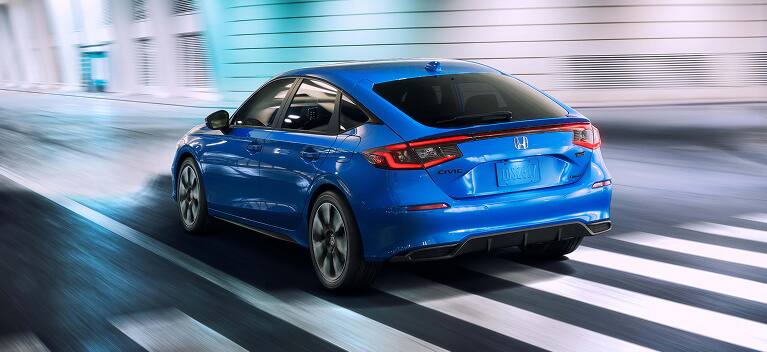 2027 Honda Civic Hatchback tSport Touring Hybrid in Boost Blue Pearl back driving through a tunnel (Compact Hatchback).
