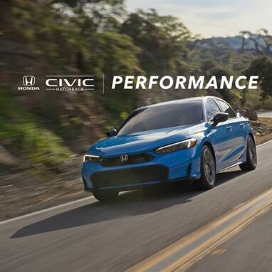 2027 Honda Civic Hatchback Sport Touring Hybrid in Boost Blue Pearl front driving on a winding road (Compact Hatchback).